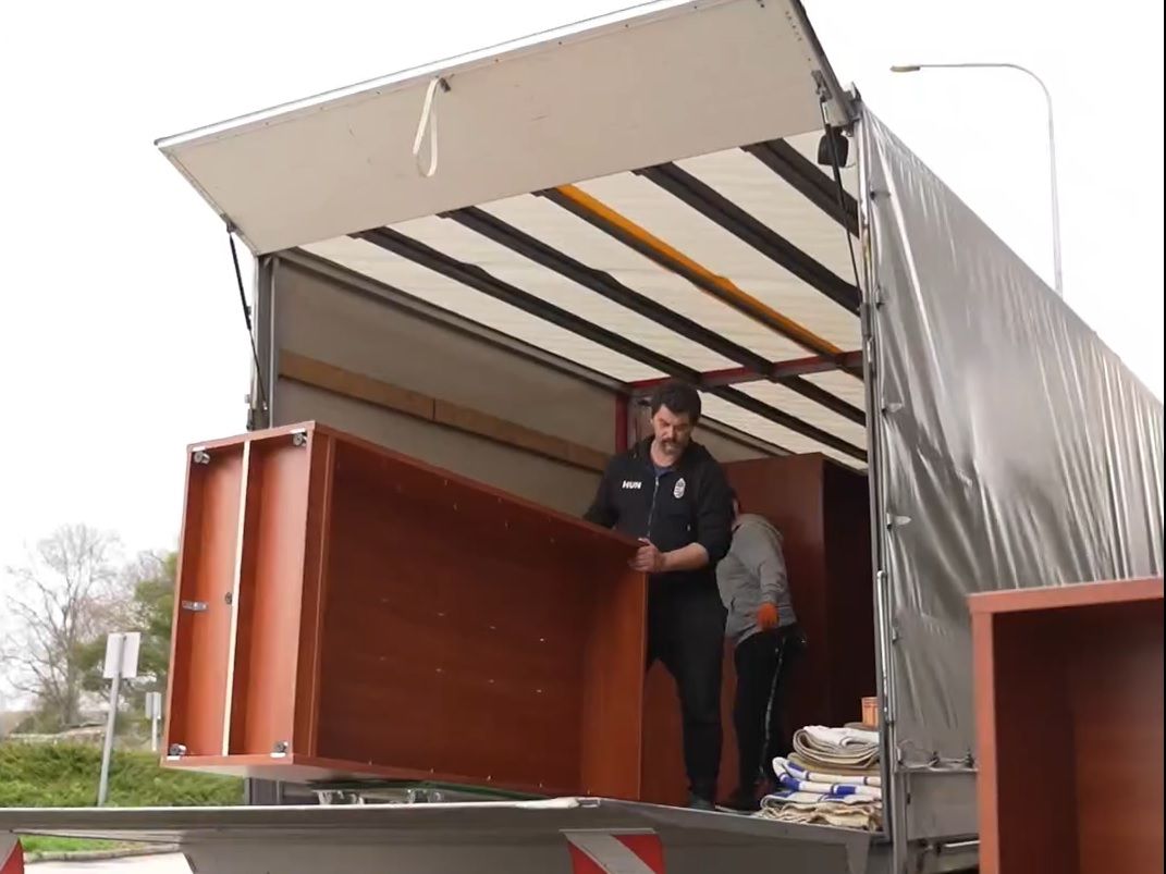 Hatalmas teherautóba pakolják a tatai művelődési ház előtt a könyveket rejtő ládákat. A költöztető cég az új tatai könyvtár épületébe viszi a 106 ezer példányból álló gyűjteményt. 