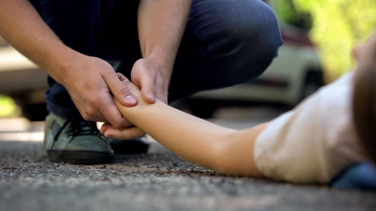 Man,Holding,Hand,Of,Girl,Lying,On,Road,,Unconscious,Victim újraélesztés