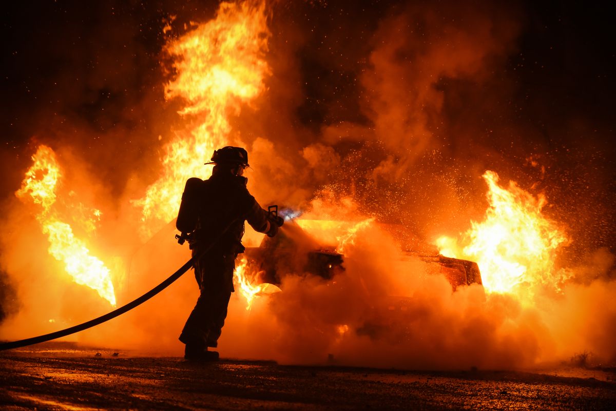 Firefighter,Extinguishes,Car,Fire