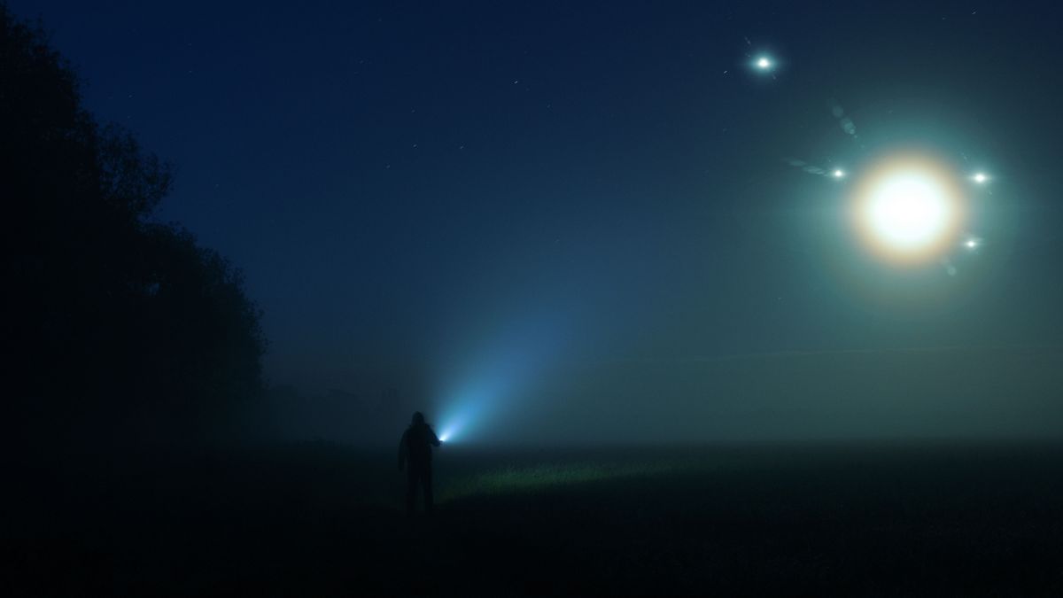 A,Man,With,A,Torch,Standing,In,The,Countryside,On, UFO